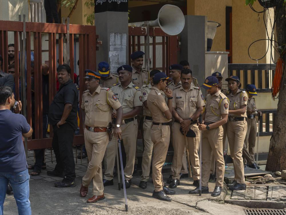 Mumbai police personnel stand guard outside the residence of Baba Siddique, a senior politician, who was shot at outside his son's office in Mumbai and later succumbed to his wounds in a hospital on Saturday night, in Mumbai, India.