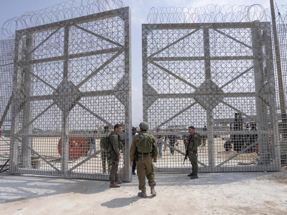 Israeli soldiers gather near a gate to walk through an inspection area for trucks carrying humanitarian aid supplies bound for the Gaza Strip, on the Israeli side of the Erez crossing into northern Gaza, on May 1.