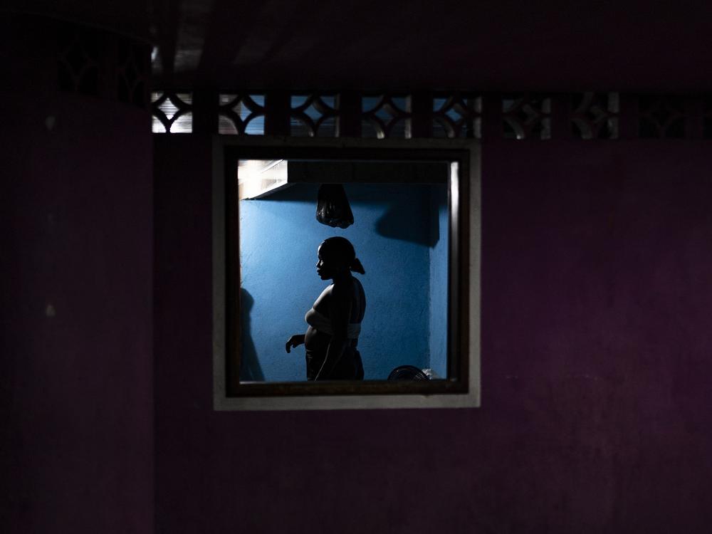 A silhouette of an Afro-Colombian woman in her home, on the night of March 28, 2024, in the town of Juntas, Buenaventura, Colombia.