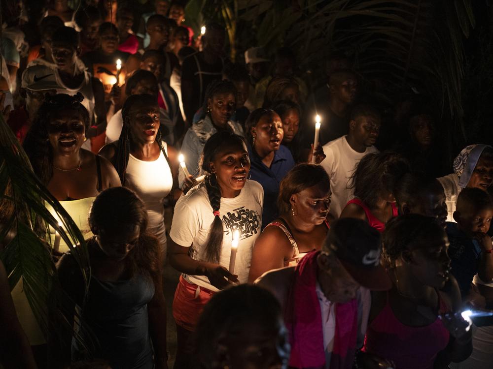 People walk through the town in a procession while singing traditional songs at midnight on March 29, 2024, in Juntas, Buenaventura, Colombia.