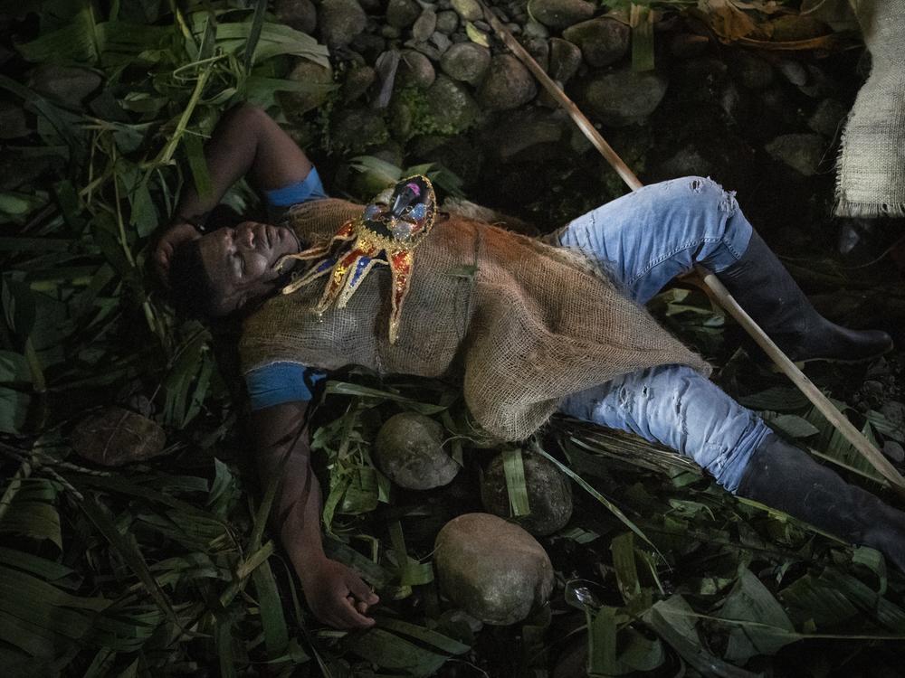 A person dressed as a Manacillo rests during a celebration on March 29, 2024, in the town of Juntas, Buenaventura, Colombia.