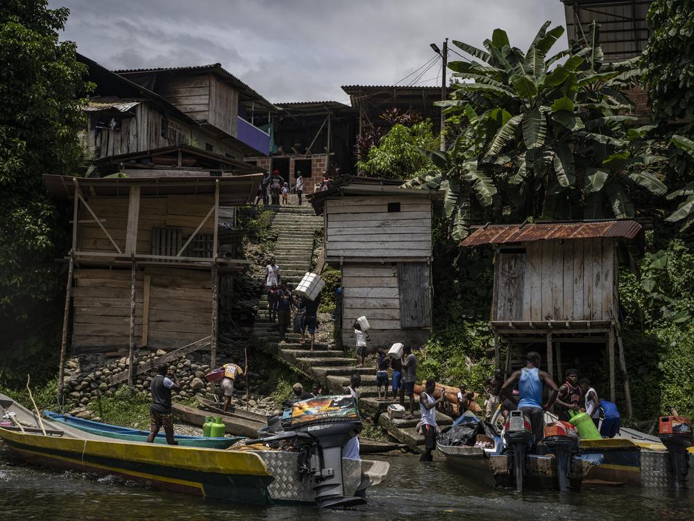 People arrive in boats to the village located on the banks of the Yurumangui River on March 28, 2024, in Juntas, Buenaventura, Colombia.