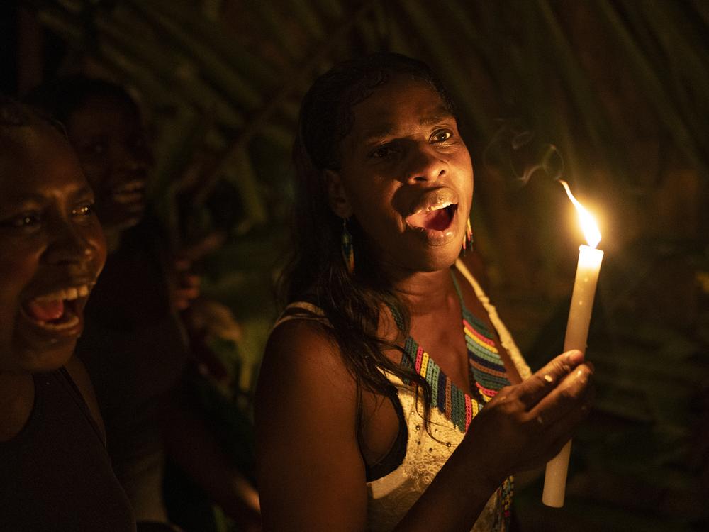 Women sing religious and ancestral songs during a Holy Week procession on March 29, 2024, in Juntas, Buenaventura, Colombia.