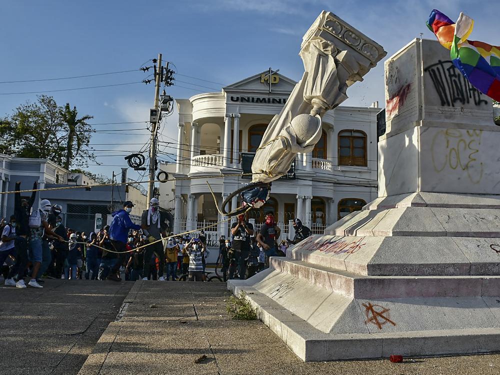 Protesters topple a statue of Christopher Columbus during a demonstration against government in Barranquilla, Colombia on June 28, 2021.