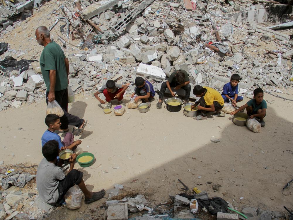 Displaced Palestinian children eat food after receiving aid distributed by a charity at Jabalia refugee camp in Gaza City, Gaza, on Sept. 23.