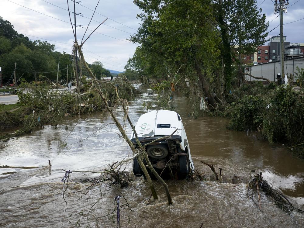A van is partially submerged in the Swannanoa River in the Biltmore Village in the aftermath of Hurricane Helene on Sunday in Asheville, N.C.