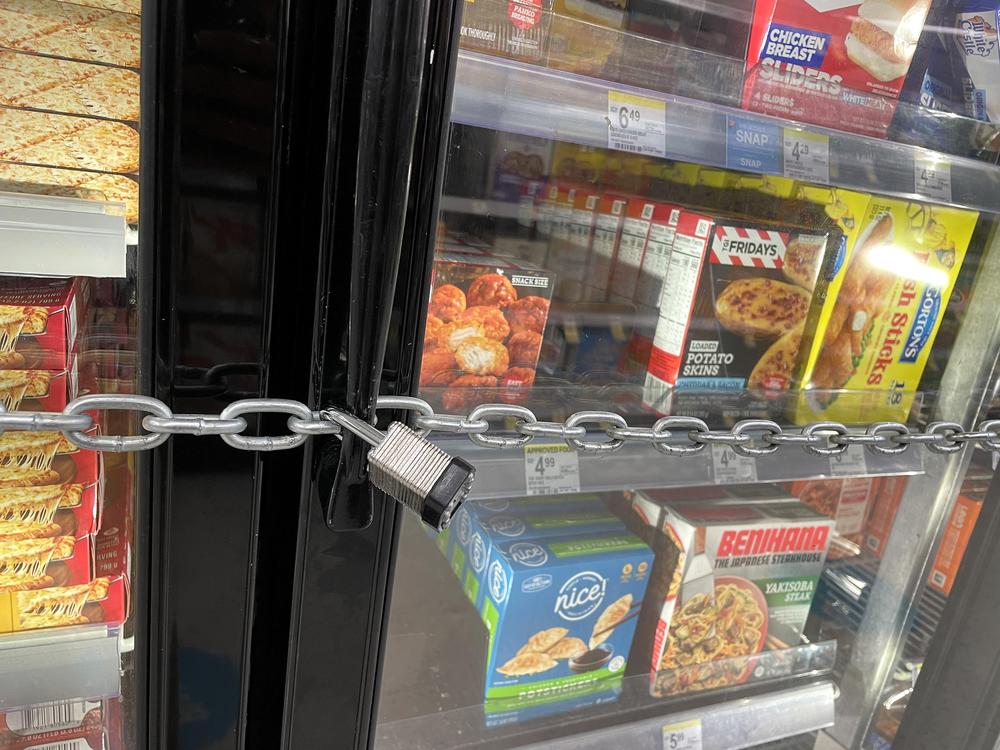A chain with a padlock secures freezer doors at a San Francisco Walgreens store in July 2023. The store padlocked its freezers to thwart shoplifters who had been stealing frozen pizzas and ice cream.