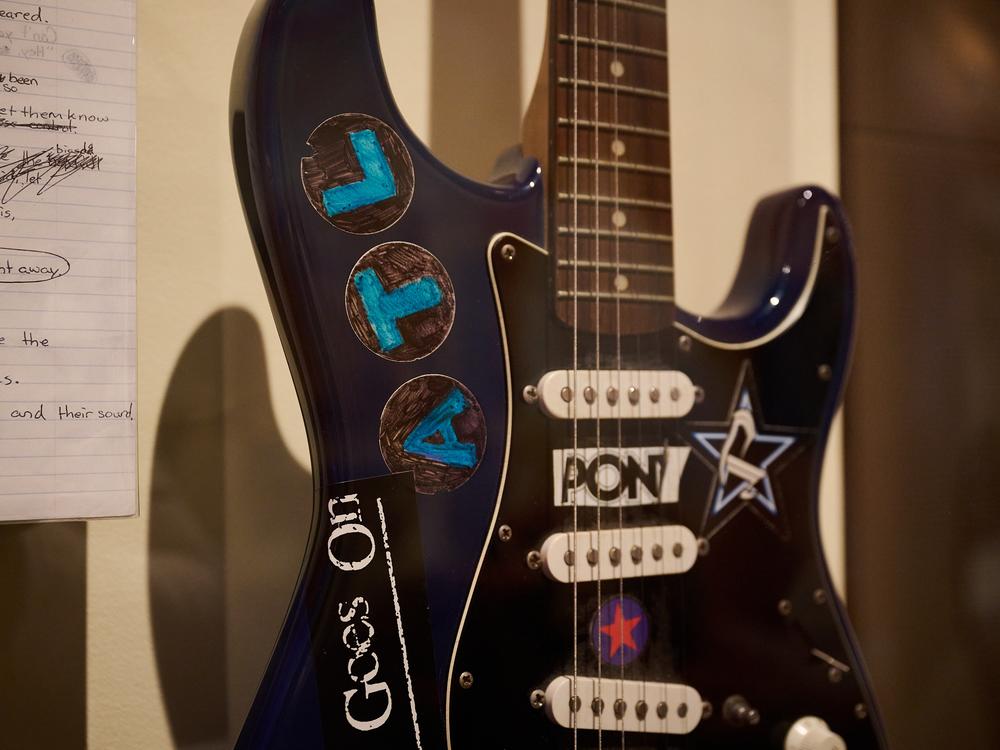 An electric guitar from Jack Barakat, of the band All Time Low, is on display.
