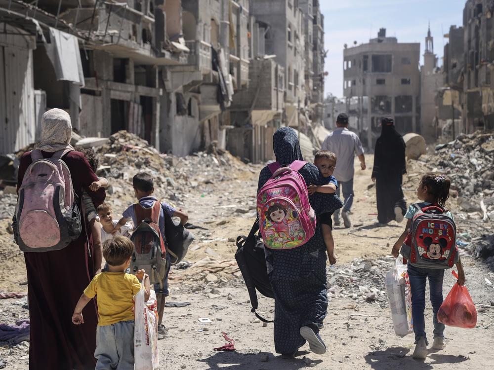 Palestinian women and their children walk though destruction in the wake of an Israeli air and ground offensive in Jabaliya, northern Gaza Strip, after Israeli forces withdrew from the area, on May 31.