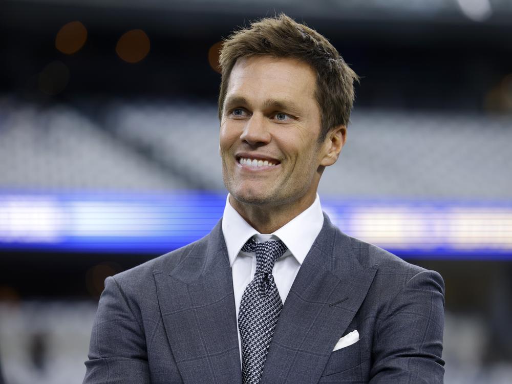 Fox Sports lead NFL analyst Tom Brady stands on the field before a game between the Detroit Lions and the Dallas Cowboys in Arlington, Texas, on Sunday. The former NFL star quarterback has purchased a minority stake in the Las Vegas Raiders.