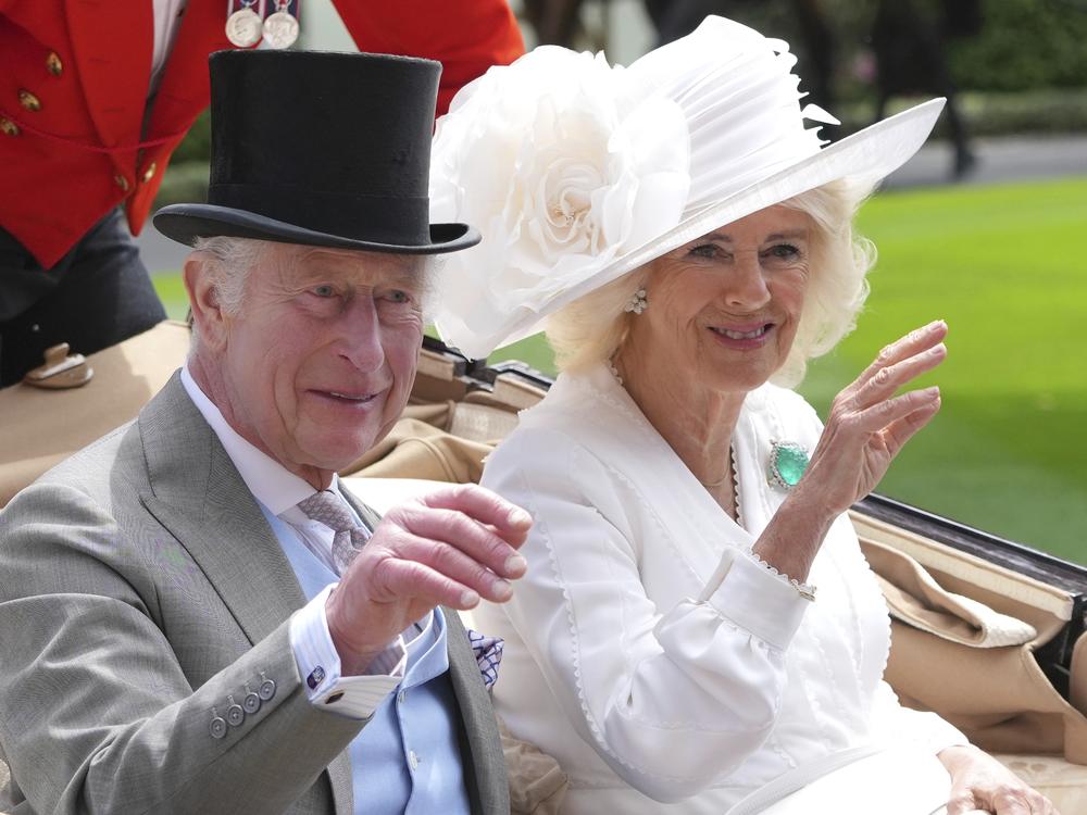 Britain's King Charles III and Queen Camilla wave to the crowds as they arrive by carriage in the parade ring on the third day of the Royal Ascot, horse race meeting, traditional known as Ladies Day, at Ascot, England, on June 20, 2024.