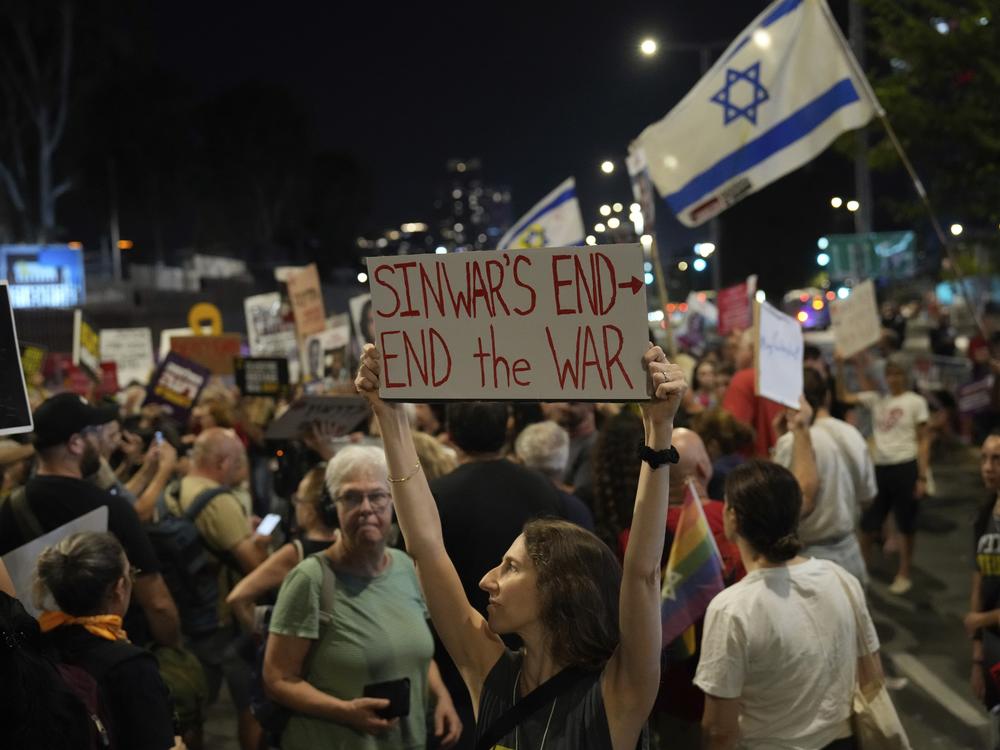 A demonstrator holds a sign about the killing of Hamas leader Yahya Sinwar during a protest calling for a cease-fire deal and the immediate release of hostages held by Hamas on Thursday, in Tel Aviv, Israel.