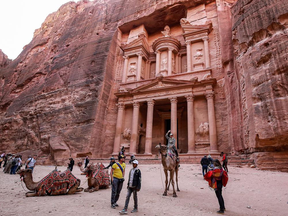 A tourist rides a camel at the Treasury site in Petra, Jordan, in December 2022. Archaeologists have discovered a hidden tomb at the site.