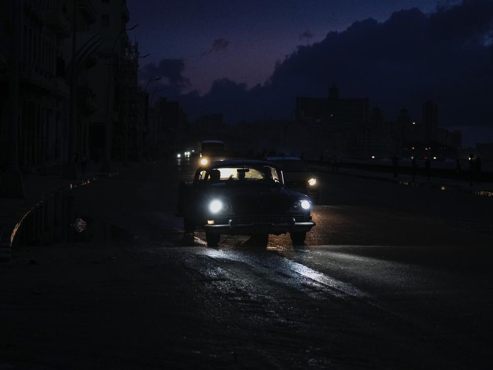 Vehicles make their way along the Malecon during a massive blackout after a major power plant failed in Havana on Friday.