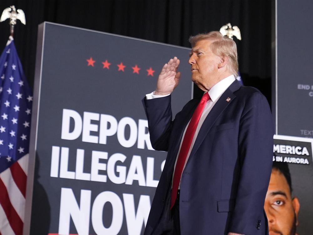 Republican presidential nominee Donald Trump salutes in Aurora, Colo., on Oct. 11. At that rally and others, he spoke of using a centuries-old act to expedite deportation of certain undocumented migrants.