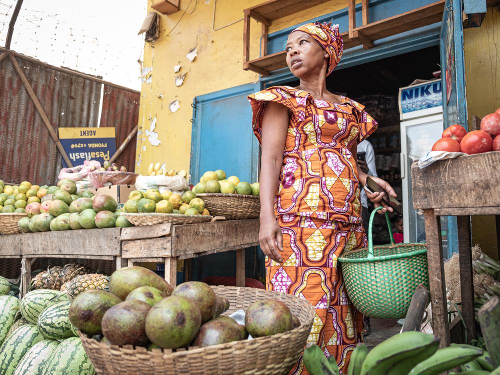 Jeannette Uwimbabazi buys food for her children at the market. 