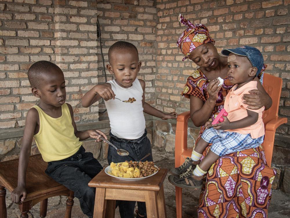 Jeannette Uwimbabazi, 40, of Bujumbura, Burundi, feeds her children beans and green bananas that she has cooked for them. As food prices have risen, the family decided to skip breakfast for the kids.