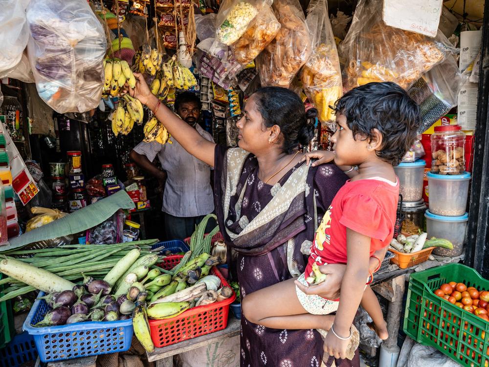 Lakshmi buys bananas for her daughter from a roadside vendor — a once-a-month treat. All fruits are expensive and beyond the family's reach on most days. But bananas, which are plentiful in India, are more affordable than the rest.<br>