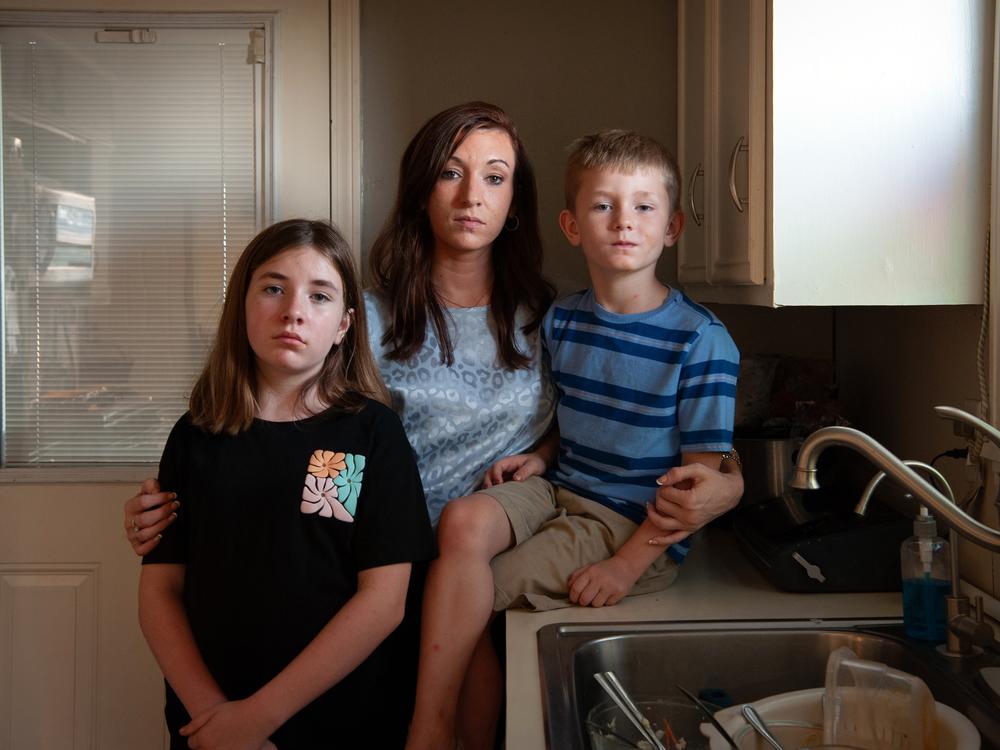 Caitlyn Kelly poses for a portrait with her two oldest children, Annadale Norris, age 10 (left), and Logan White, age 6. A single mom, she says she sometimes skips lunch so she can afford to feed her family. 