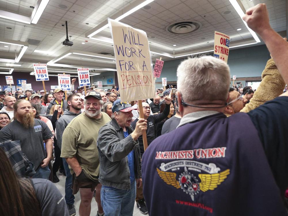 Terry Muriekes (center), a tool-storage worker at Boeing's factory in Everett, Wash., for 38 years, holds a sign during a strike rally for the International Association of Machinists and Aerospace Workers (IAM) at a union hall in Seattle on Tuesday.