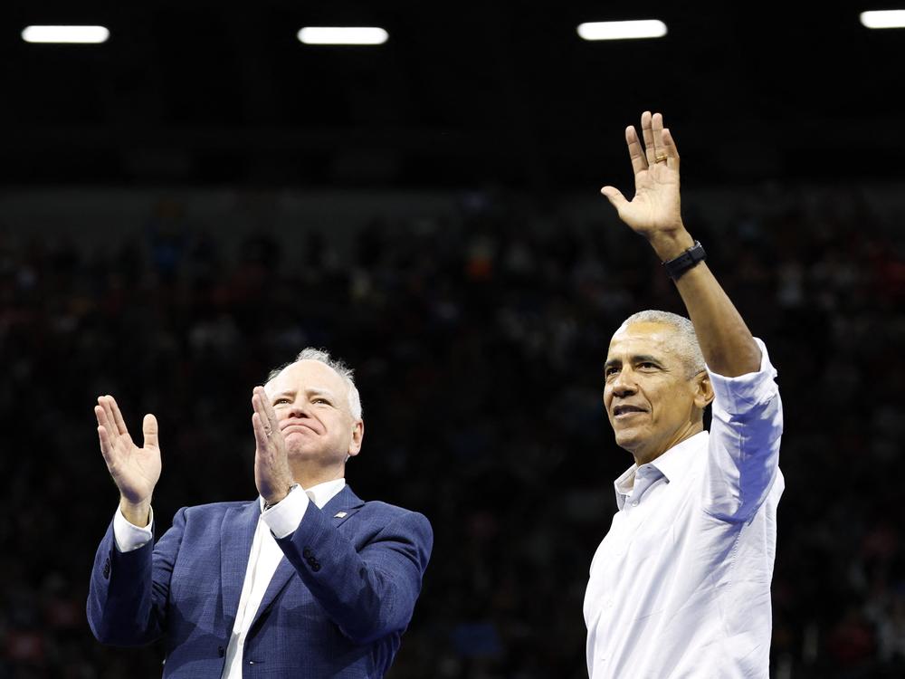 Former President Barack Obama waves next to Minnesota Governor and Democratic vice presidential candidate Tim Walz during a campaign rally in Madison, Wisconsin, on Tuesday.
