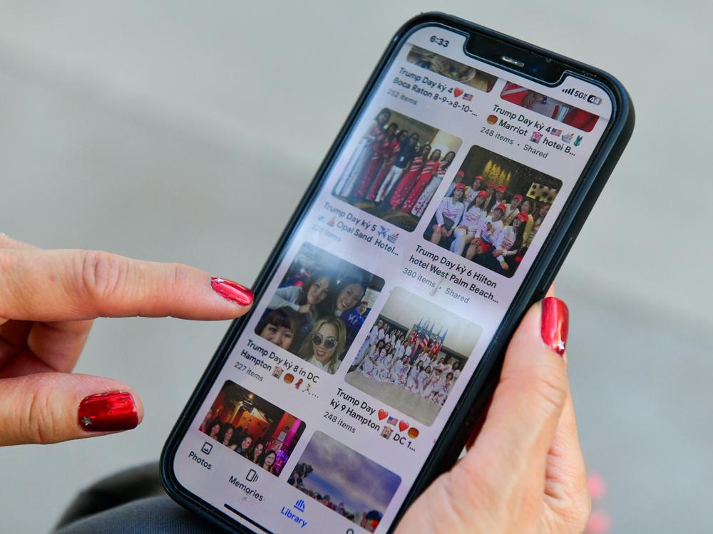 Kim Tran of Phoenix shows photo albums on her phone of members of her pro-Trump affinity group traveling together before watching Charlie Kirk at Dream City Church in Phoenix on June 5.
