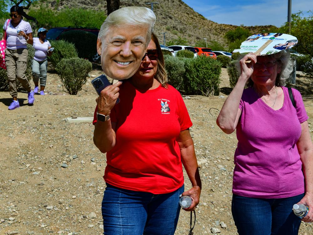 Supporters shade themselves as former President Donald Trump speaks at an event organized by Turning Point Action at Dream City Church in Phoenix on June 6.