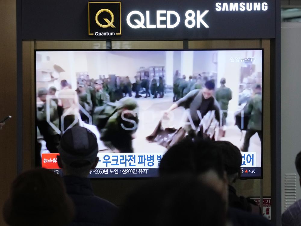 A TV screen shows an image of soldiers believed to be from North Korea stand in line to receive supplies from Russia during a news program at Seoul Railway Station in Seoul, South Korea, Monday, Oct. 21, 2024.