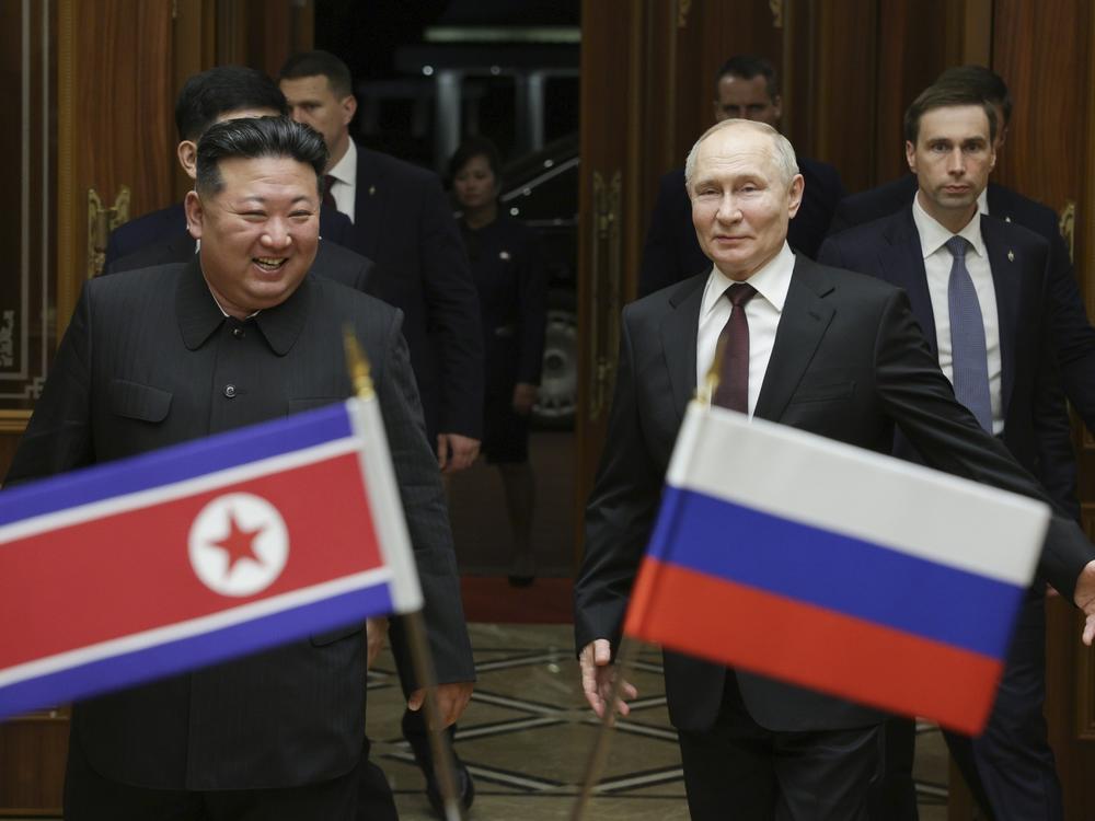 Russian President Vladimir Putin, right, and North Korea's leader Kim Jong Un smile during their meeting at the Pyongyang Sunan International Airport outside Pyongyang, North Korea, on June 19, 2024.