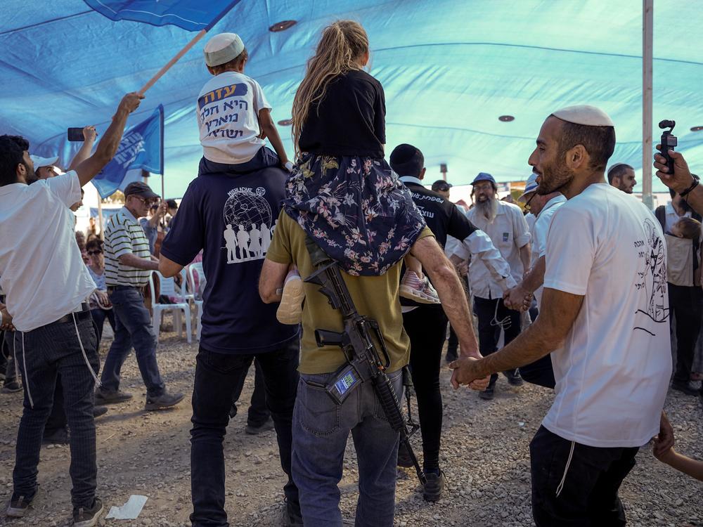 People dance during a demonstration calling for Jewish resettlement of the Gaza Strip near Israel's border with Gaza on Monday.