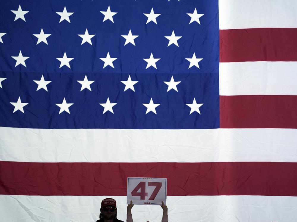A supporter holds up a sign as Trump speaks at a town hall at the Lancaster County Convention Center on Oct. 20 in Lancaster, Pa.