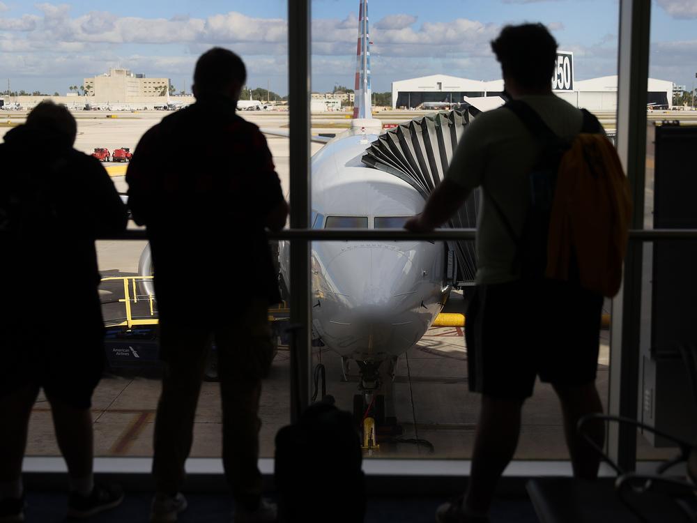 Passengers look out at an American Airlines jet. The airline is cracking down on 