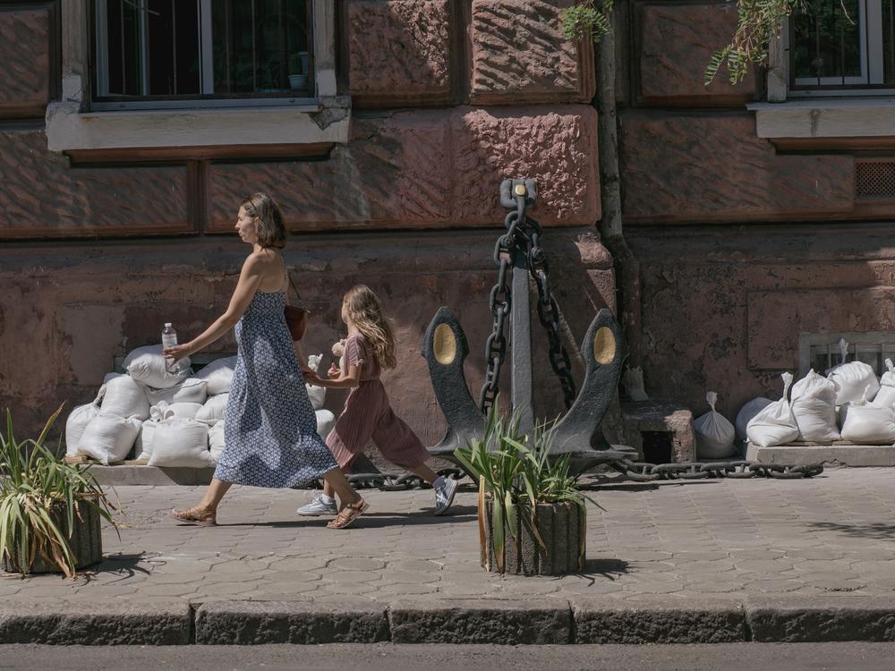 In a city that is full of life, signs of war are still visible. A mother and her daughter walk past sandbags, on Aug. 15, that are used to protect windows from the shelling.