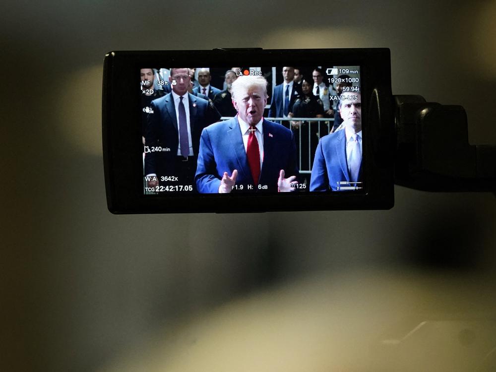 Former President Donald Trump, on a camera monitor, speaks to the press as he arrives at Manhattan Criminal Court on Feb. 15 for a hearing in his case of paying hush money to cover up extramarital affairs.