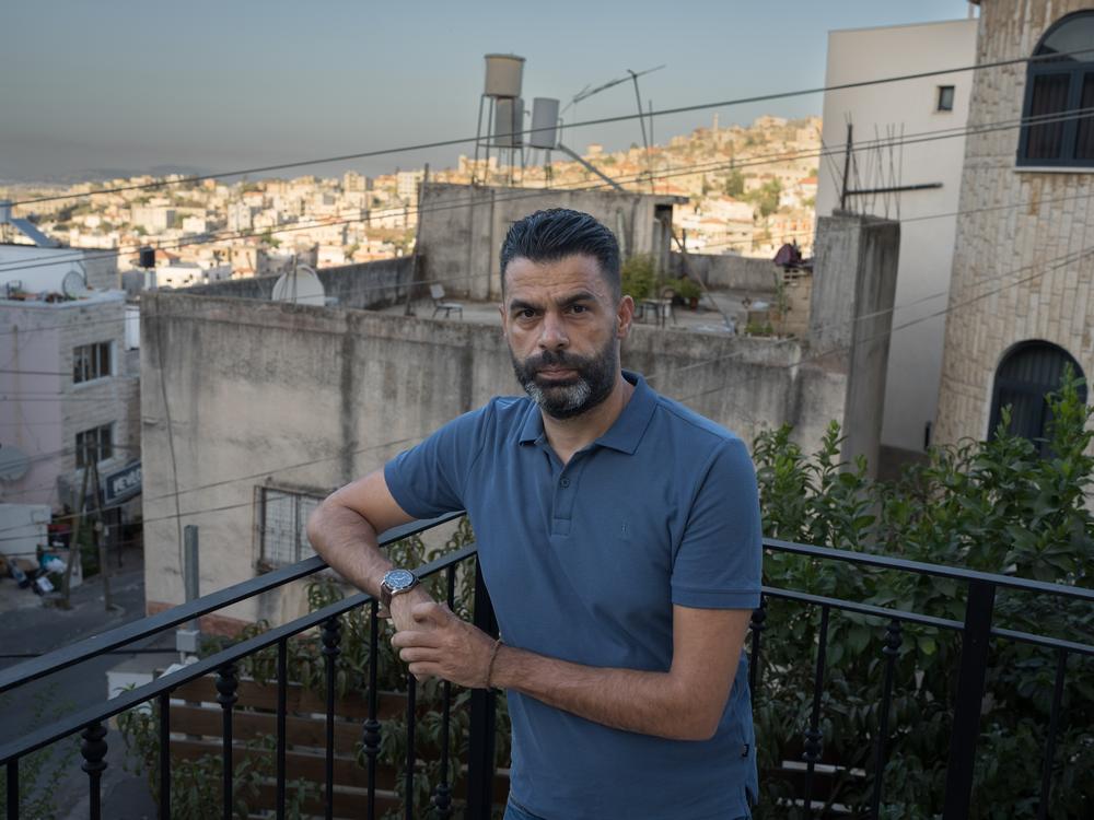 Ahmad Khalefa, 42, a human rights lawyer, poses for a portrait outside his home in Umm al-Fahm, Israel on Sept. 12. A Palestinian citizen of Israel, Khalefa was arrested for chanting anti-war slogans at a demonstration, was charged with incitement of terrorism and spent four months in Israeli prison. He is now under partial house arrest.