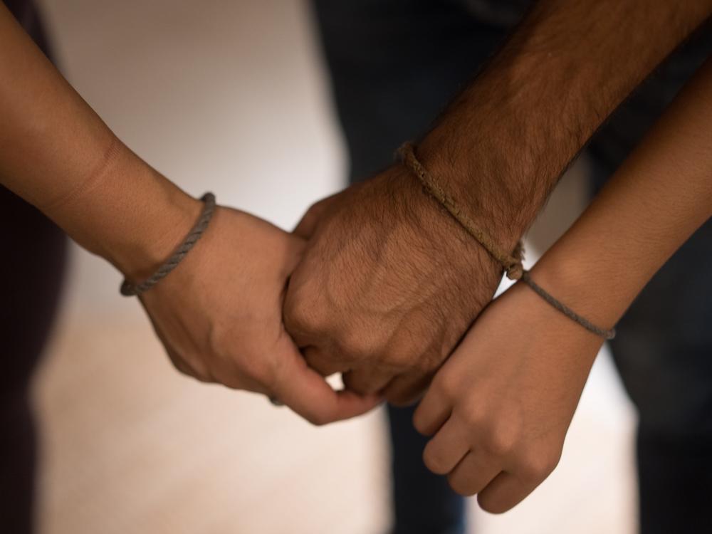Ahmad Khalefa, his wife Lina and their young daughter wear bracelets Ahmad made while in prison.
