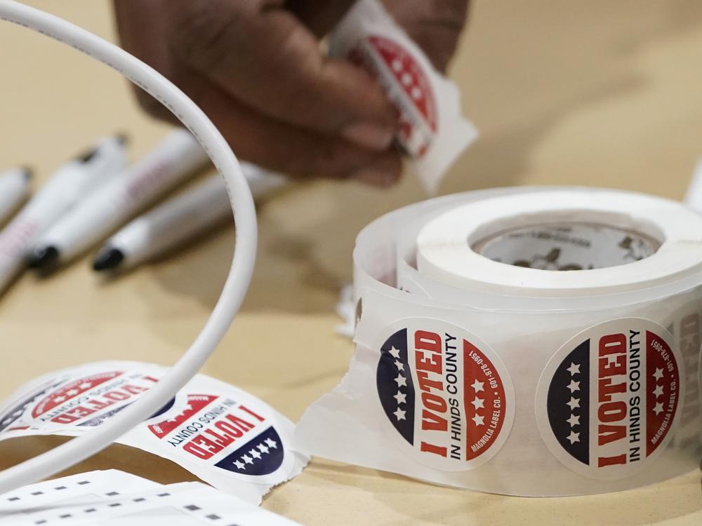 A Jackson, Miss., precinct worker reaches for more 