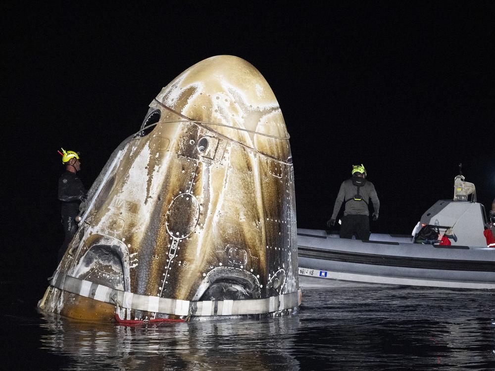 This photo provided by NASA shows support teams working around the SpaceX Dragon Endeavour spacecraft shortly after it landed,  in the Gulf of Mexico off the coast of Pensacola, Fla. on Friday.