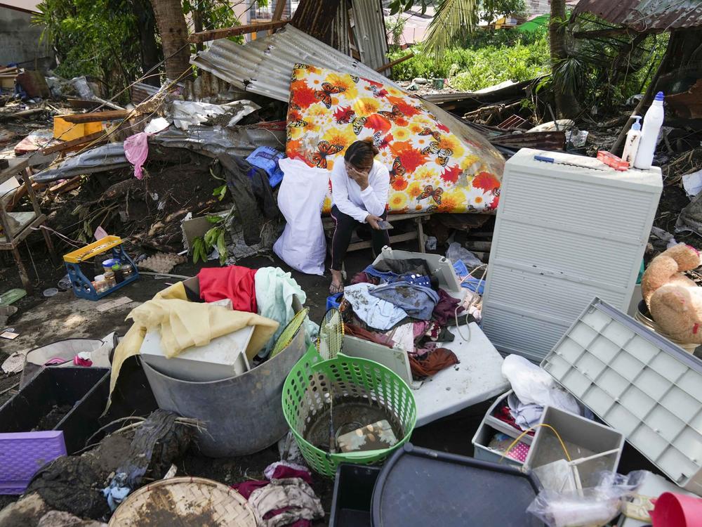 A resident sits beside belongings from their damaged home after a recent landslide triggered by Tropical Storm Trami struck Talisay, Batangas province, Philippines leaving thousands homeless and several villagers dead on Saturday, Oct. 26, 2024.