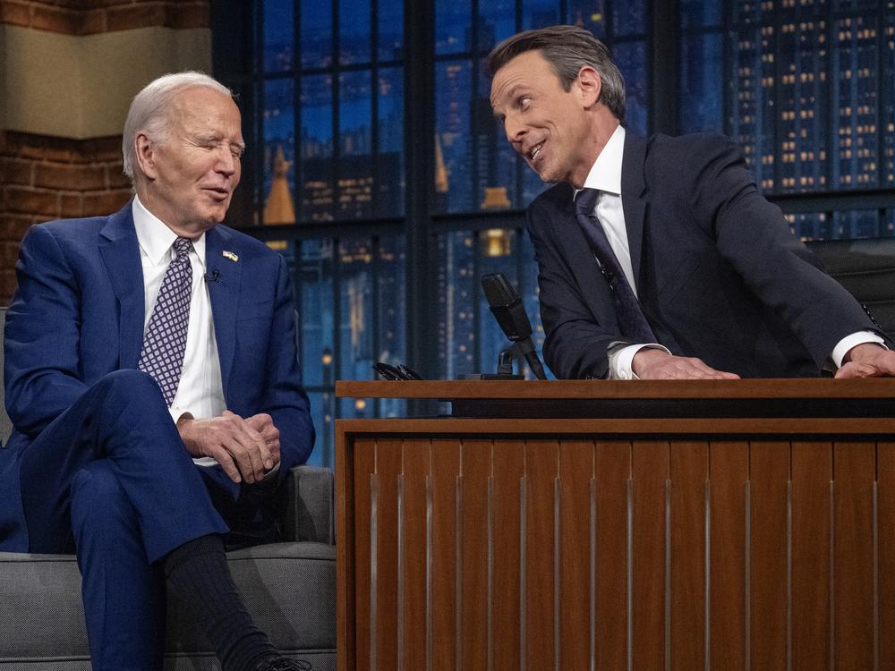Seth Meyers talks to President Joe Biden during a taping of 