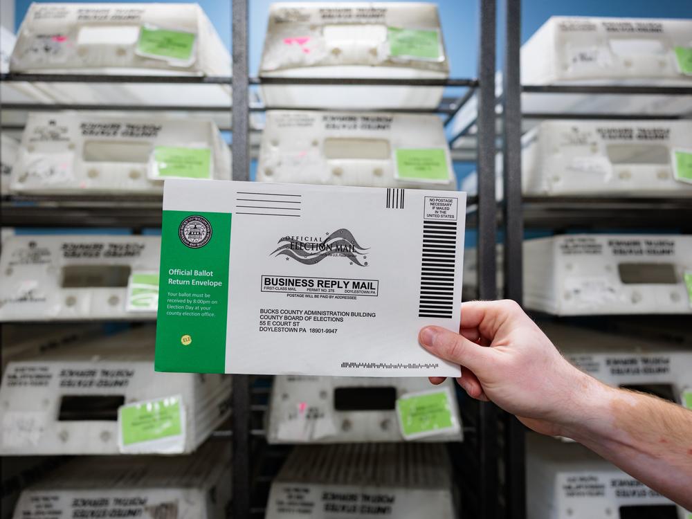 Director of the Board of Elections Tyler Burns holds a test ballot during a mail-in ballot processing demonstration on Sept. 30 in Doylestown, Pa. A fake video purporting to show ballots being destroyed in Bucks County, Pa., showed different envelopes and ballots than the county actually uses.
