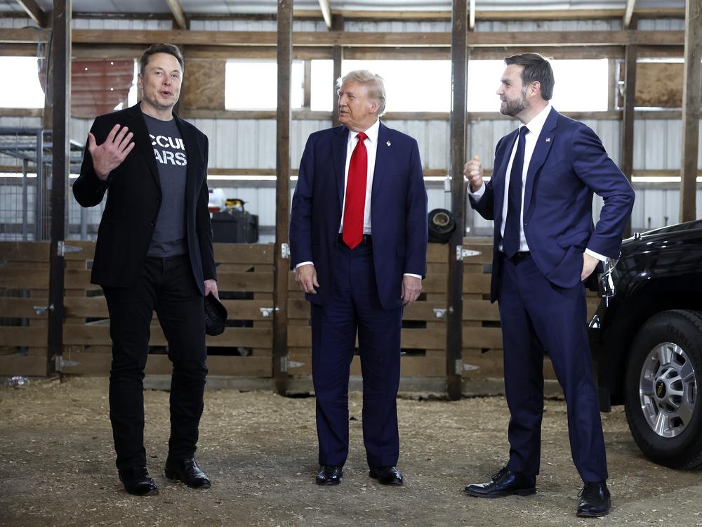 From left: Elon Musk, Republican presidential nominee Donald Trump and his running mate, Sen. JD Vance, talk to reporters backstage during a campaign rally on Oct. 5 in Butler, Pa.