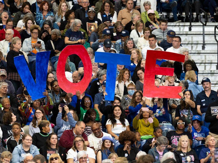 Supporters hold signs during a campaign event for Vice President Harris in Pittsburgh on Oct. 10.