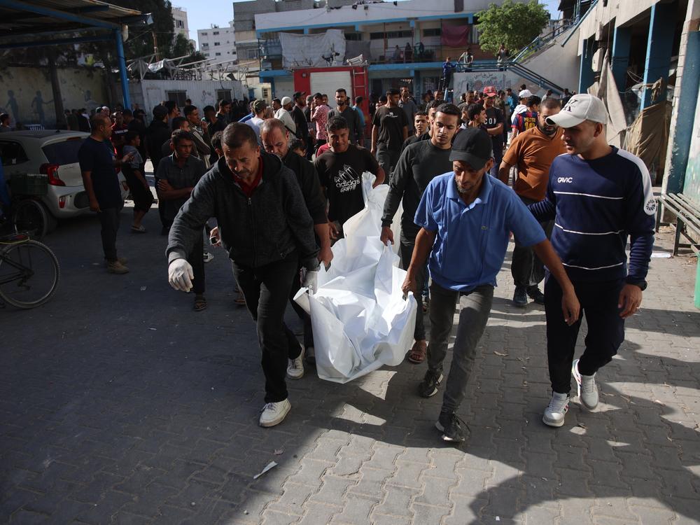 Residents and members of a civil defense team conduct search and rescue operations after the Israeli army targeted Asma School, run by the United Nations agency that aids Palestinians in the Shati refugee camp in Gaza Strip on Sunday. The wounded, including children, were brought to Shifa Hospital in Gaza City. The bodies of those who lost their lives were also brought to the hospital.