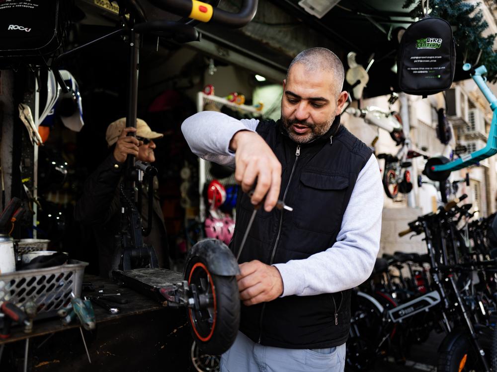 Abu Yehya works at his bicycle shop in Jaffa. After Oct. 7 last year, he says his Jewish neighbors view him with suspicion. “They walk in, see you’re Arab and walk out,” he says.
