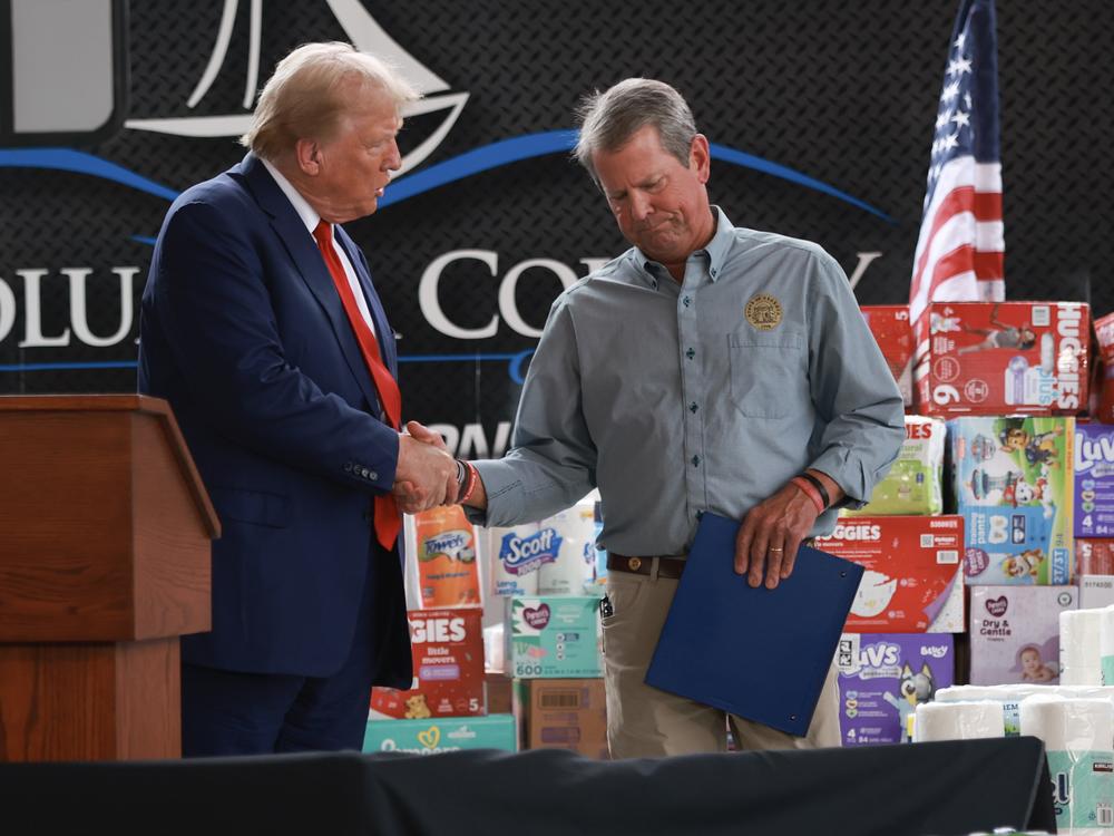 Former President Donald Trump shakes hands with Gov. Brian Kemp in Evans, Ga., following Hurricane Helene on Oct. 4.