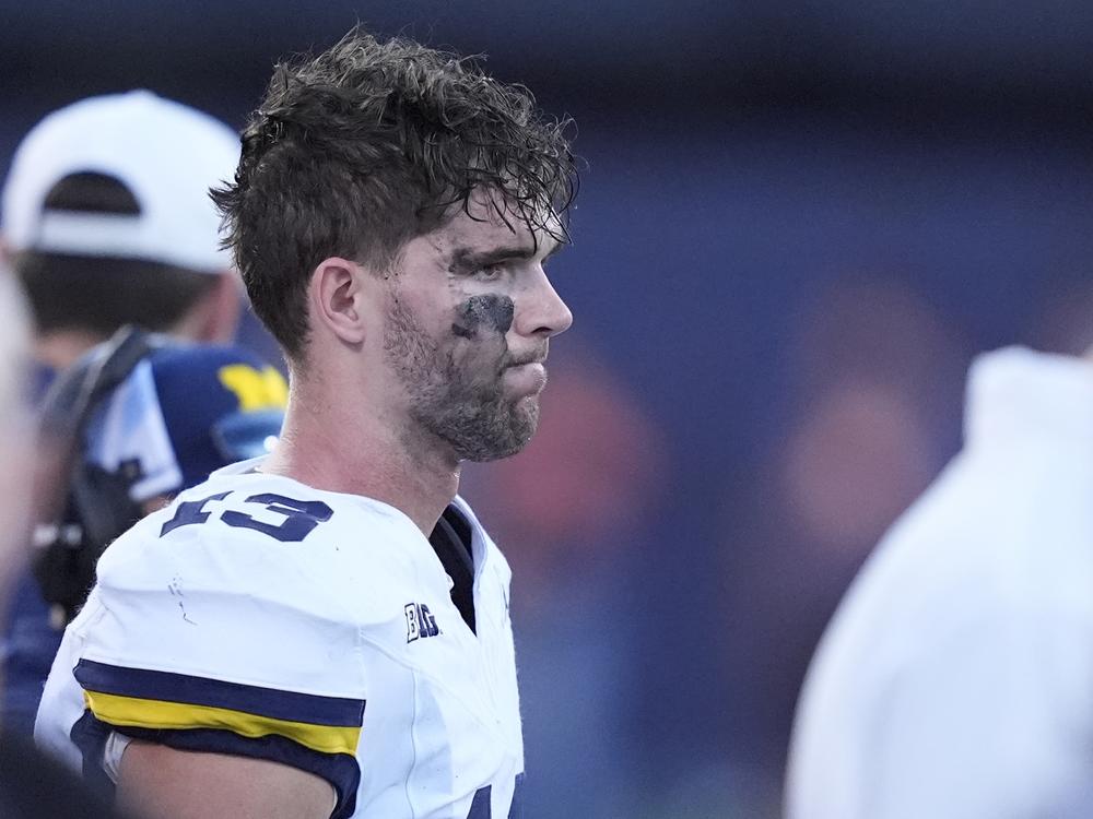 Michigan quarterback Jack Tuttle stands on the sidelines in the closing minutes of the team's 21-7 loss to Illinois in an NCAA college football game Saturday, Oct. 19, 2024, in Champaign, Ill.