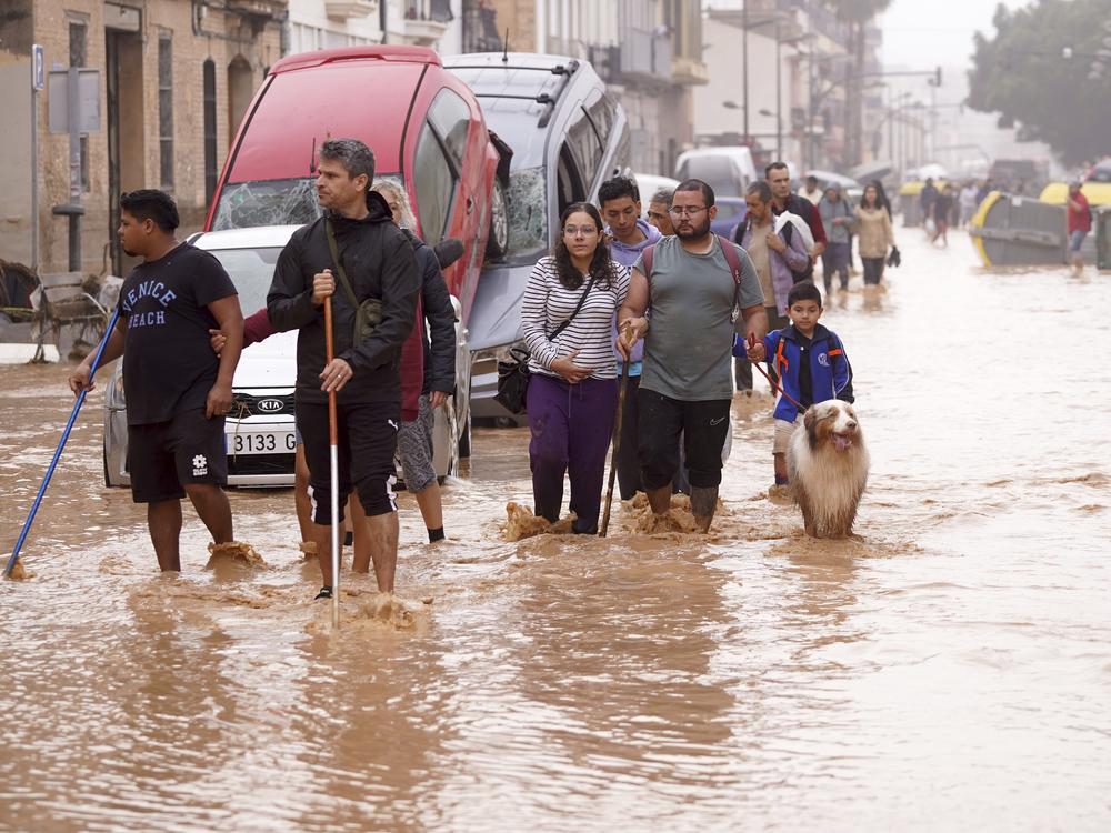 People walk through flooded streets in Valencia, Spain.