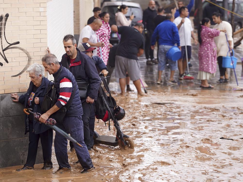 People walk through flooded streets in Valencia, Spain.