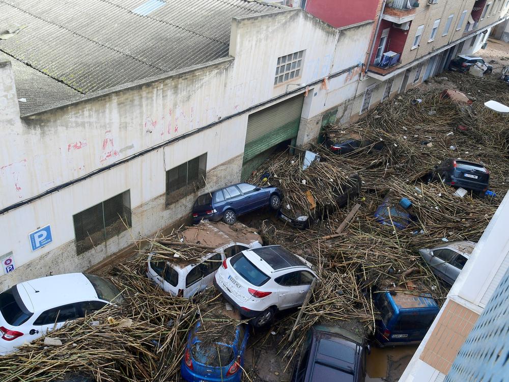 A picture taken in Picanya, near Valencia, eastern Spain, shows cars piled in a street after floods.